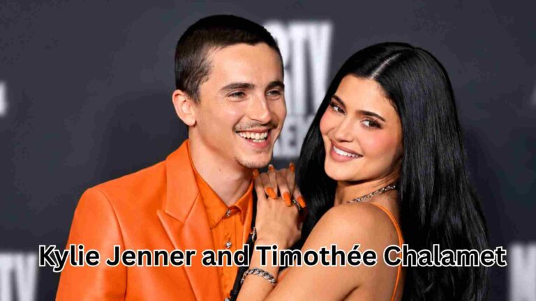 Kylie Jenner and Timothée Chalamet posing together at a red carpet event in matching orange outfits